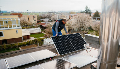 Worker installing new solar panels on roof of family house. Eco concept alternative energy