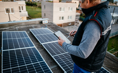 Worker installing new solar panels. New solar module for family house. Eco concept alternative...