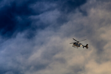 Fototapeta na wymiar police helicopter in sky with clouds