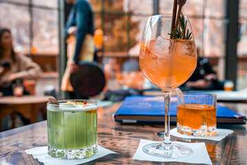 Close-up of orange and green colored drinks. Favoured beverages are served on dining table. Concept of catering in restaurant at ski resort.