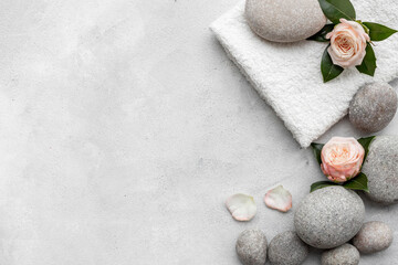 Fototapeta na wymiar Spa massage stones with pink roses, beauty treatment background