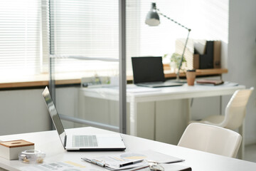 Modern portable computer, clipboard with documents on office table in open space office