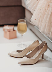 woman shoes and a glass of champagne and gift box next to a couch with festive dress. holiday or birthday party concept.