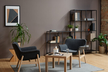 Fototapeta premium Horizontal no people shot of modern psychologist office interior in gray and brown colors with two chairs and coffee table