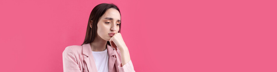 Portrait of beautiful young woman in pink jacket thinking isolated on red background