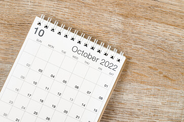 October 2022 desk calendar on wooden background.