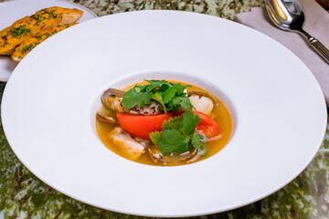 fish soup with seafood on a white plate