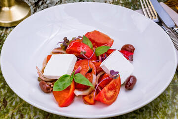 tomatoes bull's heart sliced with onion and cheese on white plate
