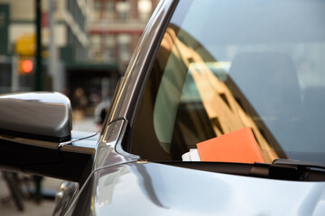 Modern car with a parking ticket on its window in New York City.
