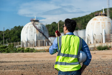 worker in helmet. person in helmet with oil tanks in the desert onbackground. © ENGINEER - STUDIO