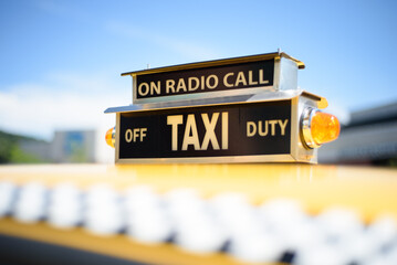 Vintage roof top taxi cab sign on a yellow car.