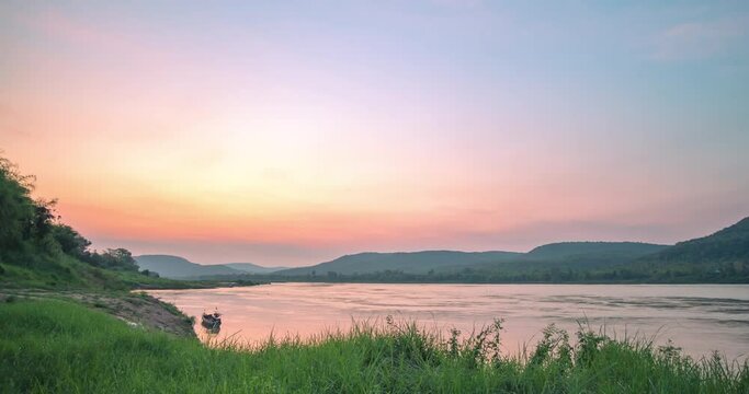 Time lapse from Dawn to sunrise over the Mekong river with a small fishing boat on the river at Pa Taem Ubon Ratchathani province Northeast Thailand. 