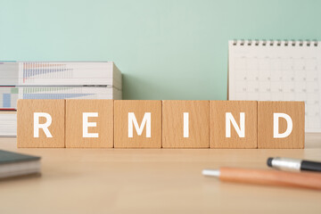 リマインドのイメージ｜「REMIND」と書かれた積み木が置かれたデスク