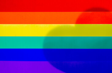 Pride or rainbow flag made from colorful paper with shadow of love shape for Pride day and LGBTQ concept.