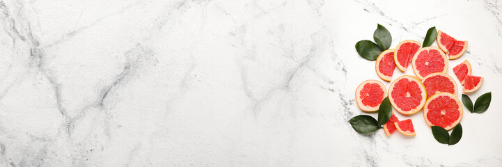Fresh sliced grapefruit on light marble background with space for text