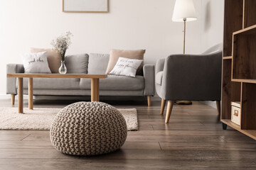 Comfortable pouf on wooden floor in living room