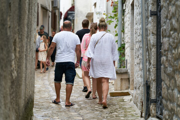 Obraz na płótnie Canvas Tourists walking through the historic old town of Krk in Croatia