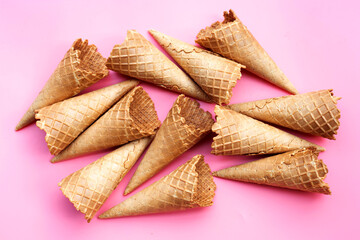 Empty ice cream cone on pink background.