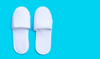 Hotel slippers on blue background. Copy space