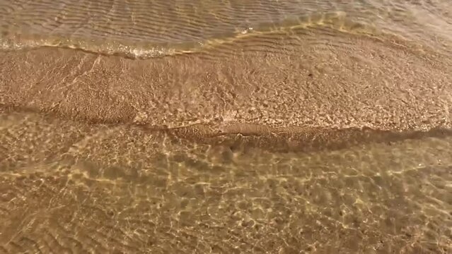 Waves hit the sandy beach super slow motion