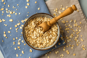 Bowl with raw oatmeal flakes and napkins on table