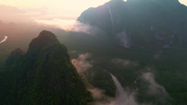 4K : Drone flying above the clouds, Limestone mountains with mangrove forests and rivers at Phang Nga Bay. Samed Nang Chee. Phang Nga Province, Thailand
