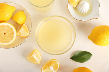 Composition with glass bowl of lemon juice and on light background