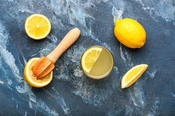Composition with ripe lemons, juicer and glass of juice on color background