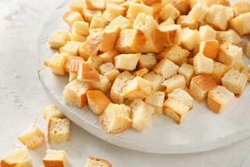 Plate with tasty croutons on white background, closeup