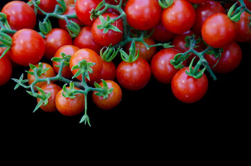 Red ripe tomatoes on black background