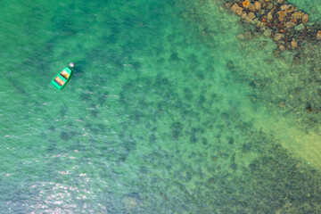 boat anchored to some rocks bathed by a crystal clear, 23 April 2022