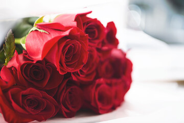 A view of a bouquet of red roses, on the left side of the frame.