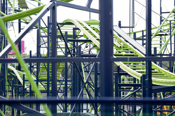 Fototapeta premium A view of the structure system of a green and blue colored roller coaster.