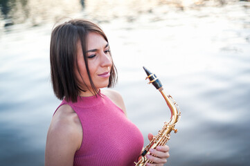 Woman playing the saxophone at sunset.