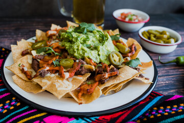 Mexican nachos chips with american cheese, beer and jalapeños in Mexico Latin America