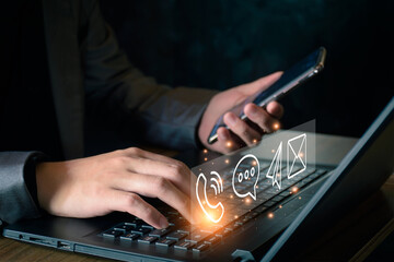 Concept of business communication. Businessman using computer and smartphone to contact customers via online internet, meeting, global network, shape icon phone email mail message on virtual screen.