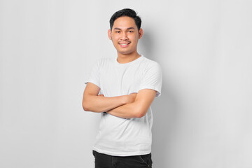 Portrait of smiling young Asian man crossed arms chest and looking confident isolated on white background