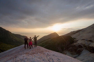 Fototapeta na wymiar tourists stand on the mountain and admire the sunset, Sakhalin. Kuriles