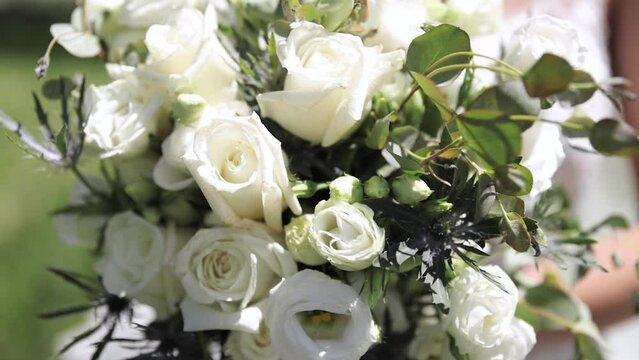 Close Up of Bride in Her Wedding Dress Holding Large Flower Wedding Bouquet in Her Hands Outdoors with White Roses and Greenery 1080p 60fps