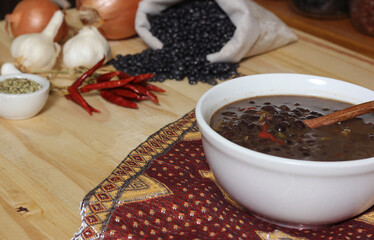 Black Bean Chili on Wooden Table With Spices and Dried Black Beans