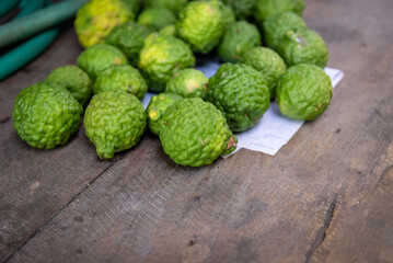 Kaffir limes, bergamot, ingredient for healthy thai food and beauty products on wood table.