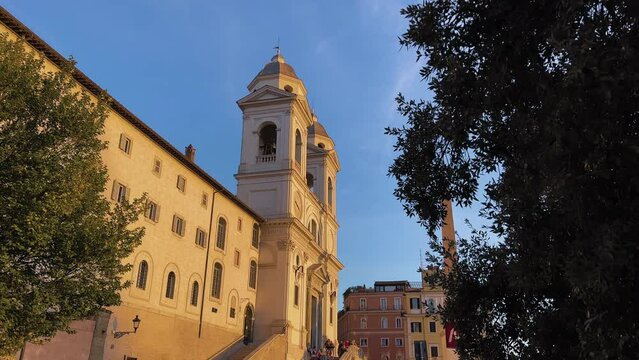 Pov shot of Santissima Trinit&agrave; dei Monti Church lighting by sun in Rome,Italy