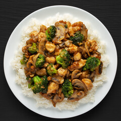 Homemade Chicken Veggie Stir Fry with White Rice on a black background, top view. Close-up.