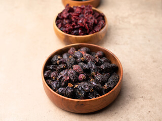 Healthy dried fruit, cranberry, prunes in a wooden bowl top view flatlay. Tasty food photo with copy space banner background.