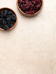 Healthy dried fruit, cranberry, prunes in a wooden bowl top view flatlay. Tasty food photo with copy space banner background.
