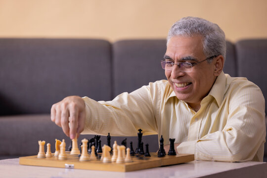 Portrait Of Senior Man Playing Chess At Home