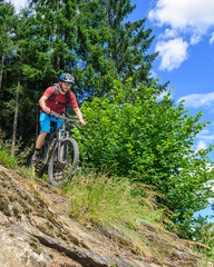 Fototapeta na wymiar Verwegener Mountainbiker befährt sehr steiles Gelände