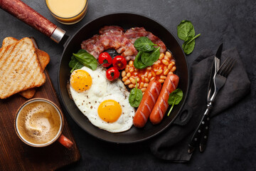English breakfast with fried eggs, beans, bacon and sausages