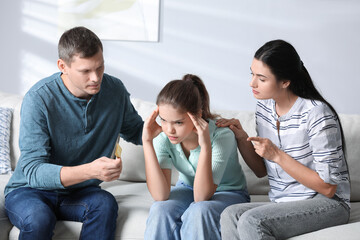 Parents talking with their teenage daughter about contraception at home. Sex education concept