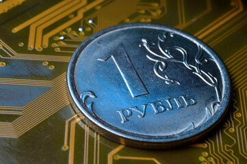 A coin with a face value of 1 ruble lies on a microcircuit. close-up. Translation of the inscription on the coin: "1 ruble" The concept of the digital economy in the Russian Federation